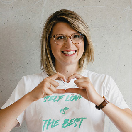 Frau formt mit ihren Händen ein Herz