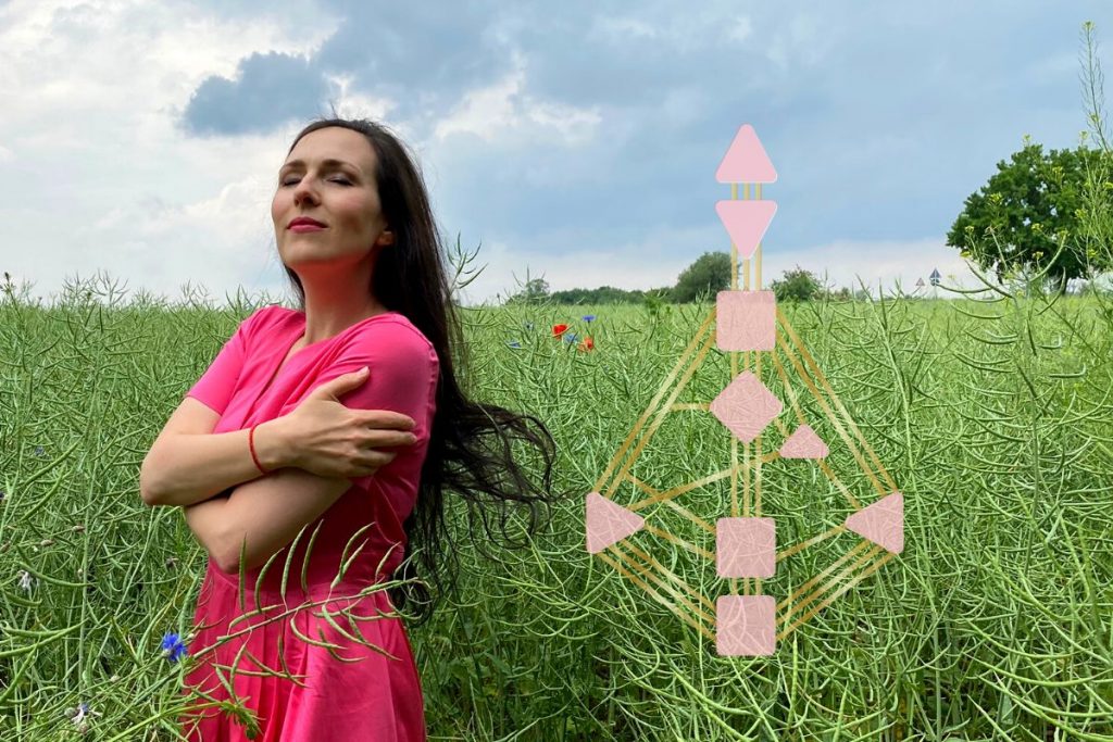 Frau umarmt sich selbst auf einer grünen Wiese mit hohem Gras